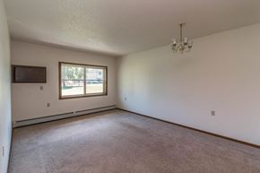 Milaca apartment for rent - an empty living room with a window and a chandelier