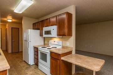 West Fargo townhouse for rent - a kitchen with white appliances and wooden cabinets