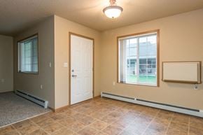 West Fargo townhouse for rent - a empty living room with a white door and a window