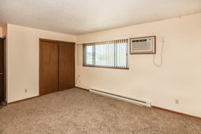 Whitewood apartment for rent - an empty living room with an air conditioner and a window