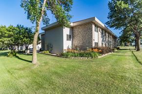 Little Falls apartment for rent - A house with a lawn and trees in front of it.