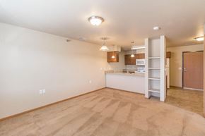 Bismarck apartment for rent - the living room and kitchen of an empty house with a ladder in the corner
