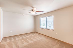 Bismarck apartment for rent - an empty living room with a ceiling fan and a window