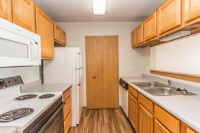 Bismarck apartment for rent - a kitchen with white appliances and wooden cabinets