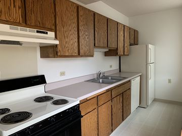 Jamestown apartment for rent - a kitchen with white appliances and wooden cabinets