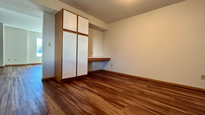 North Branch apartment for rent - an empty living room with wood floors and a white refrigerator