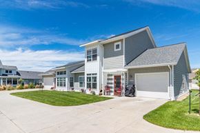 Mandan apartment for rent - a house with a garage and a driveway in front of it