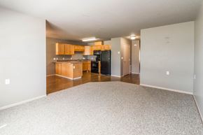 Cambridge apartment for rent - an empty living room and kitchen with wood cabinets