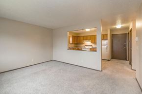 Dickinson apartment for rent - an empty living room with a kitchen in the background