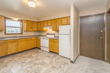 Dickinson apartment for rent - a kitchen with wooden cabinets and a white refrigerator