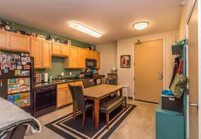Minot apartment for rent - a kitchen and dining room with a table and a refrigerator
