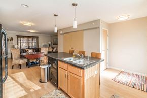 Minot apartment for rent - a kitchen with an island and a dining room with a table and chairs