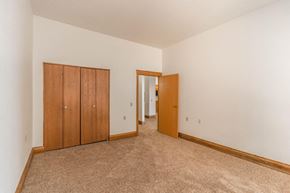 Devils Lake apartment for rent - a empty living room with carpet and a door to a hallway