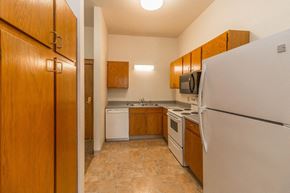 Devils Lake apartment for rent - a kitchen with white appliances and wooden cabinets and a refrigerator