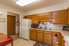 Monticello apartment for rent - a kitchen with a sink and refrigerator and wooden cabinets