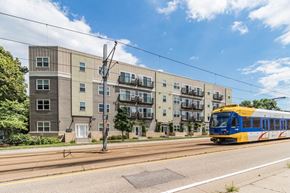 Minneapolis apartment for rent - a blue and yellow train traveling past an apartment building
