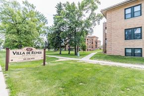Grafton apartment for rent - A sign for Villa de Remer stands in a grassy area in front of a building.