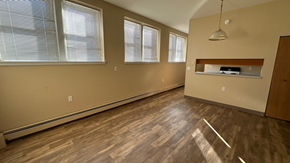 Grafton apartment for rent - A room with wooden flooring and three windows.
