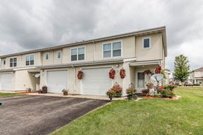Owatonna townhouse for rent - the front of a white house with wreaths on the garage doors
