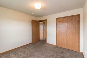 Owatonna townhouse for rent - an empty bedroom with a closet and a door to a hallway