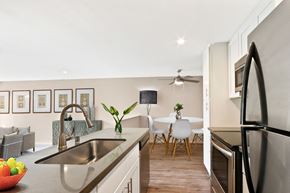 Los Angeles apartment for rent - A kitchen with a sink, refrigerator, and a dining table with chairs.