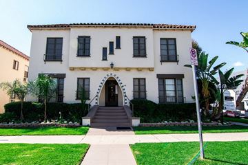 Los Angeles apartment for rent - A white building with a red roof and a sign on the right side.