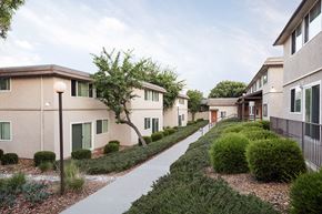 San Diego apartment for rent - a row of apartment buildings with a sidewalk and landscaping