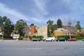San Diego apartment for rent - a street with cars parked in front of an apartment building