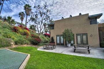 San Diego apartment for rent - A house with a green lawn and a pool.