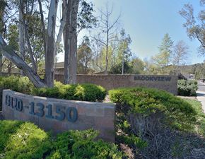 Poway apartment for rent - a brick retaining wall with a sign that reads moonwehr and a building behind