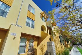 San Diego apartment for rent - a yellow building with a sidewalk in front of it