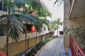 San Diego apartment for rent - a street with palm trees next to a building