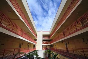 San Diego apartment for rent - an empty building with red balconies and a blue sky