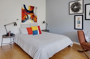 Allston apartment for rent - a bedroom with a white bed and colorful pillows