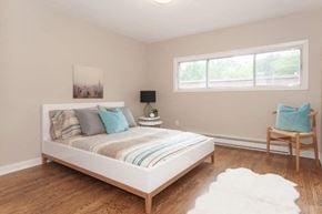 Ottawa apartment for rent - A bedroom with a large bed and a chair.