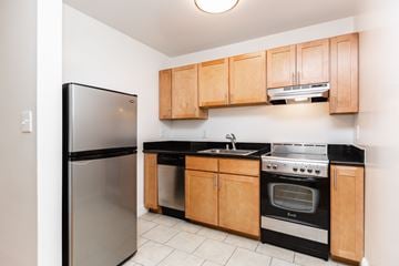 San Francisco apartment for rent - A kitchen with wooden cabinets and black countertops.