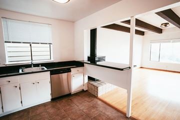 San Francisco apartment for rent - A kitchen with white cabinets and a black countertop.