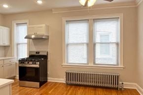 Oak Park apartment for rent - A kitchen with a stove, oven, and a window with blinds.
