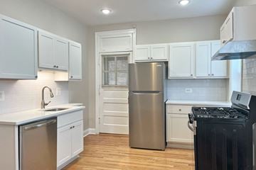 Oak Park apartment for rent - A kitchen with white cabinets and a stainless steel refrigerator.