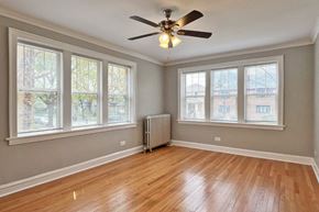 Oak Park apartment for rent - A room with a ceiling fan and wooden flooring.