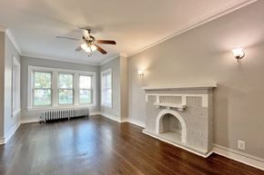 Oak Park apartment for rent - A living room with a fireplace and a ceiling fan.