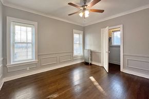 Oak Park apartment for rent - A room with a ceiling fan and wooden floors.