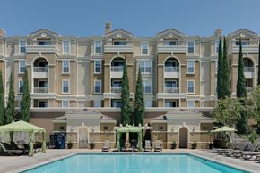 Santa Ana apartment for rent - A large building with a pool in front of it.