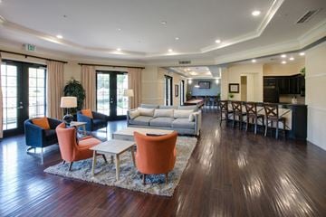 Santa Ana apartment for rent - A living room with a grey couch and orange chairs.