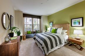 Santa Ana apartment for rent - A bedroom with a large bed and a wooden nightstand.