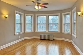 Oak Park apartment for rent - A room with a ceiling fan and wooden floors.