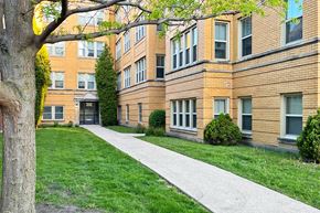 Oak Park apartment for rent - A tree is in front of a building with a brick facade.