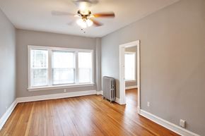 Chicago apartment for rent - an empty living room with wood floors and a ceiling fan