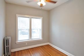 Chicago apartment for rent - an empty room with a ceiling fan and two windows