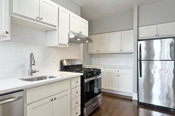 Oak Park apartment for rent - A kitchen with white cabinets and a stainless steel refrigerator.